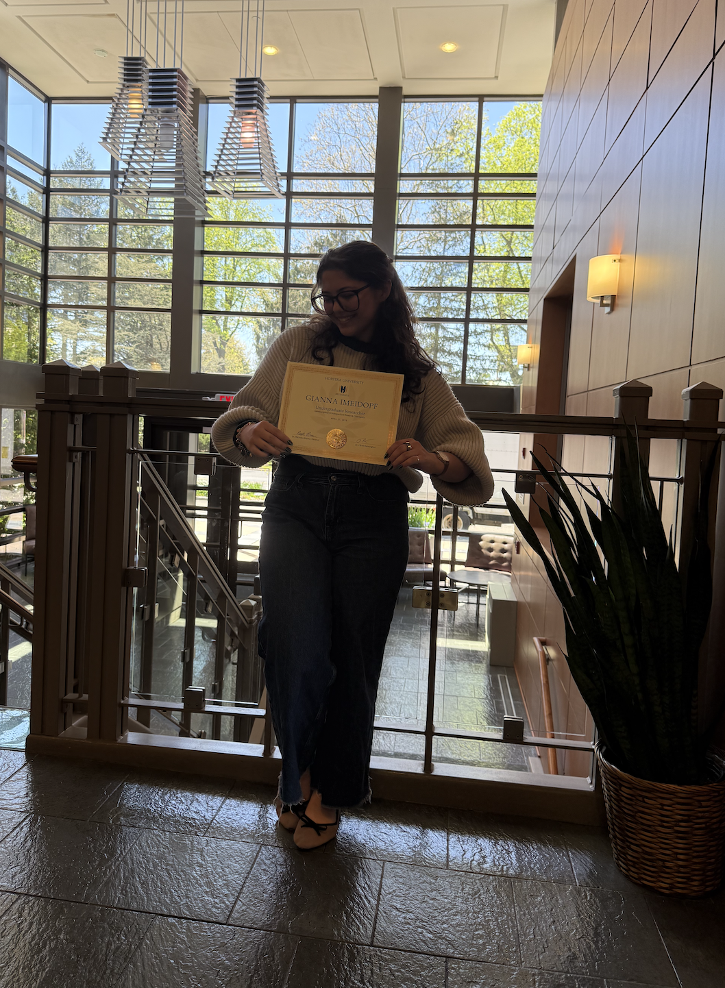 IURC recognition photo holding certificate in atrium